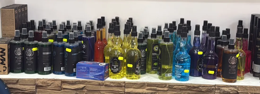 Regalbrett an einer Steinwand mit einer langen Reihe bunter Barber-Colognes (Foto aus dem Google-Eintrag)