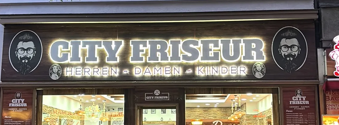 Hinterleuchteter Schriftzug „CITY FRISEUR — HERREN · DAMEN · KINDER“ über dem Schaufenster an der Turmstraße (Foto aus dem Google-Eintrag)
